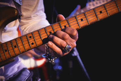 Midsection of man playing guitar