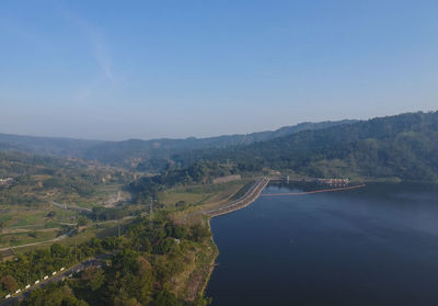 Scenic view of river by mountains against clear sky