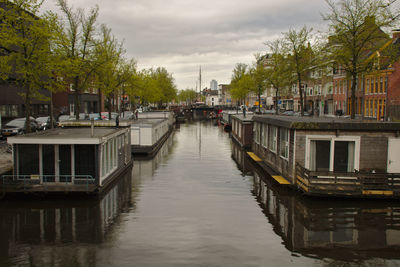 Canal amidst buildings in city against sky