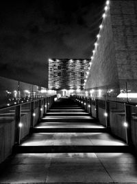 Illuminated street amidst buildings at night