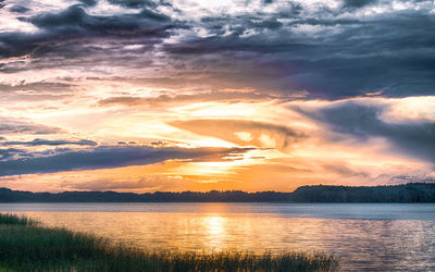 Scenic view of sea against dramatic sky during sunset