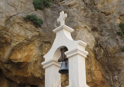 Low angle view of bell against rock formation