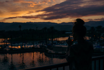 Woman drinking whiskey from the balcony in palm springs resort