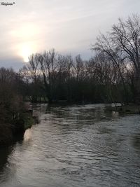 Scenic view of river against sky at sunset