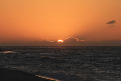 Scenic view of sea against orange sky