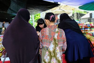 Rear view of women with people walking outdoors