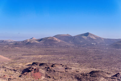 Scenic view of arid landscape against clear blue sky