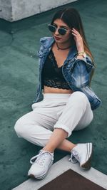 Young woman wearing sunglasses sitting outdoors