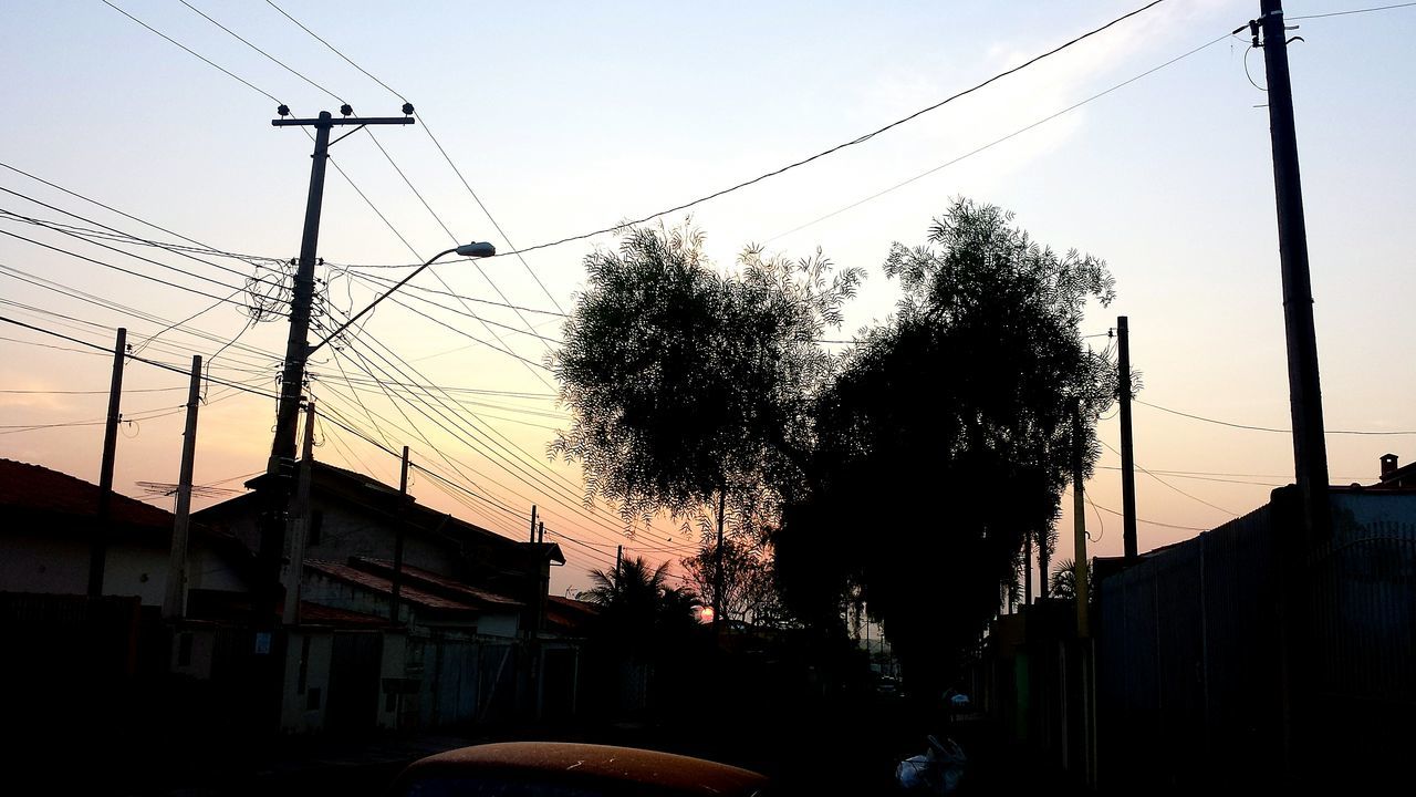 silhouette, building exterior, built structure, architecture, clear sky, sunset, sky, bird, low angle view, power line, fence, cable, street light, animal themes, electricity pylon, outdoors, animals in the wild, house, wildlife, connection