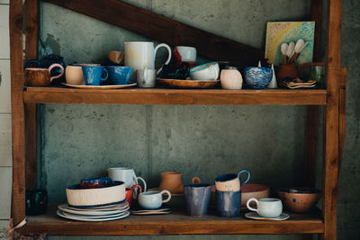 Kitchen utensils in shelf at home