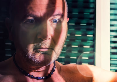 Close-up portrait of shirtless young man