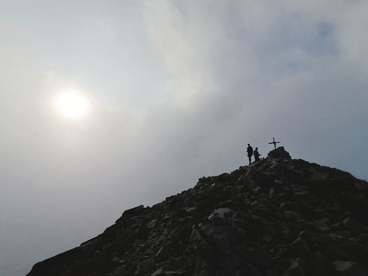 LOW ANGLE VIEW OF PEOPLE STANDING ON ROCK