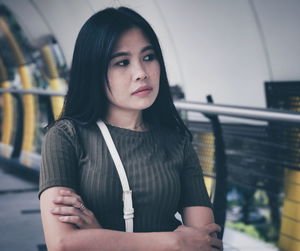 Close-up portrait of young woman standing against wall