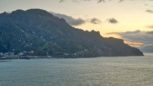 Scenic view of sea and mountains against sky