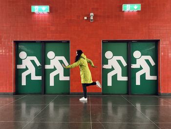 Rear view of woman walking on wall