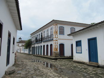 Footpath amidst buildings against sky