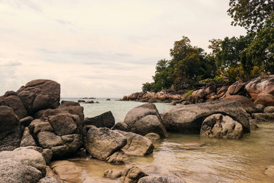 Rocks on beach against sky