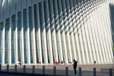 People walking on modern glass building in city