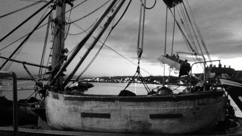 Boats moored at harbor against sky