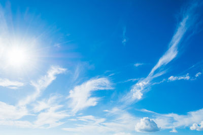 Low angle view of sunlight streaming through clouds