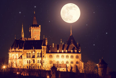 Digital composite image of illuminated buildings against sky at night