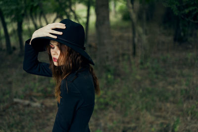 Rear view of woman standing in forest