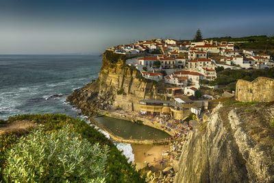 High angle view of buildings by sea against sky