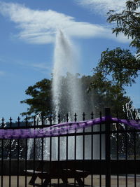 Low angle view of water splashing on fountain against sky