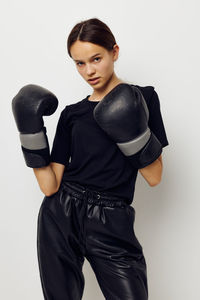 Portrait of young woman standing against white background