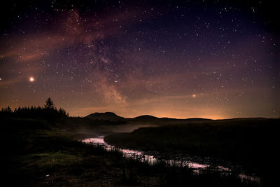 Scenic view of landscape against sky at night