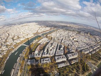 High angle view of city buildings against cloudy sky