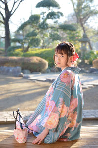 Portrait of smiling young woman sitting outdoors