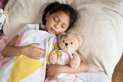 High angle view of baby girl sleeping on bed