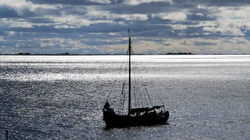 Sailboat on sea shore against sky
