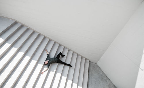 High angle view of woman sitting on staircase