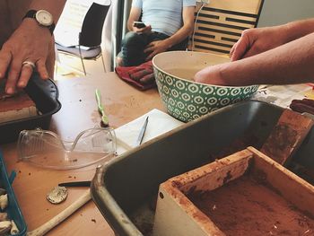 Cropped hands of people working on table