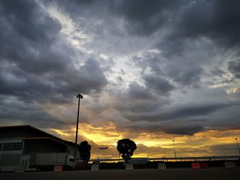 Silhouette street against sky at sunset