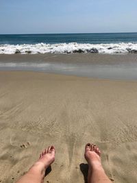 Low section of woman relaxing at beach