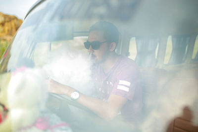 Full length of young woman standing in car