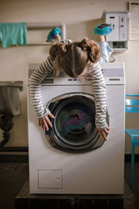Teenage girl using common laundry to save resources and money. sustainability and environment care