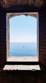 Scenic view of sea against sky seen through window