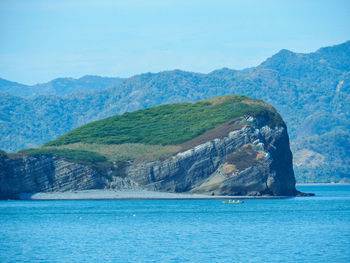 Scenic view of sea and mountains against sky