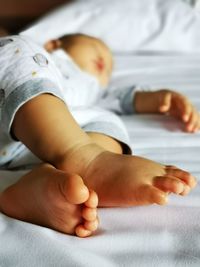 Midsection of baby lying on bed