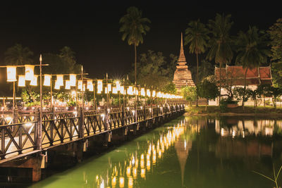 Panoramic view of canal by building against sky at night