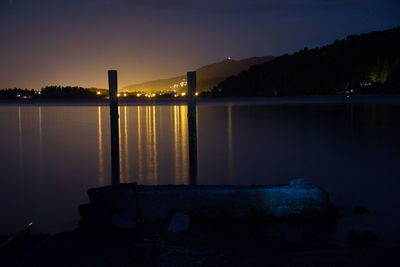 Scenic view of lake against sky at night