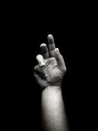 Close-up of human hand over black background