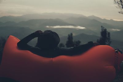 Close-up of young woman in mountains against sky