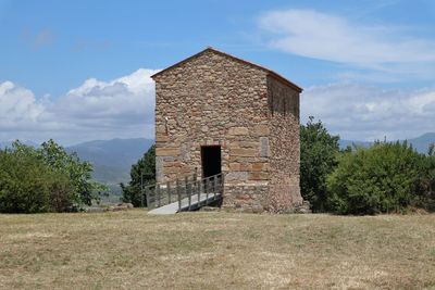 Old building on field against sky