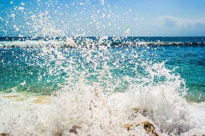 Water splashing in sea against sky