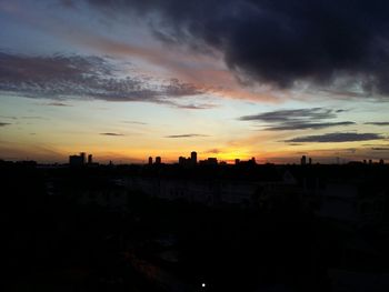 High angle view of silhouette buildings against sky at sunset
